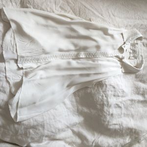 A white silk sleeveless blouse with sequin detail.