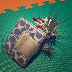 COACH folding wallet with gold details.