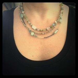 Three-strand beaded necklace in blues and greens.