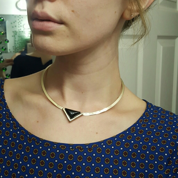 Gold choker necklace with black triangle detail.