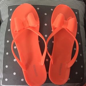 Neon orange bow flip flops
