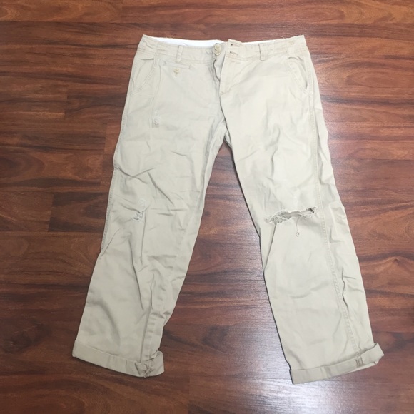 Khaki capris with a ripped knee and rolled bottoms