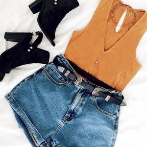 Orange top, cure shorts, and black boots