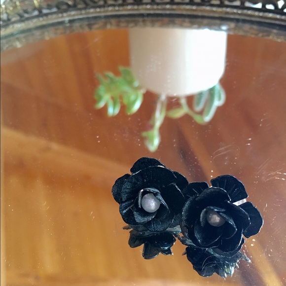 Black rose stud earrings with pearl detail.