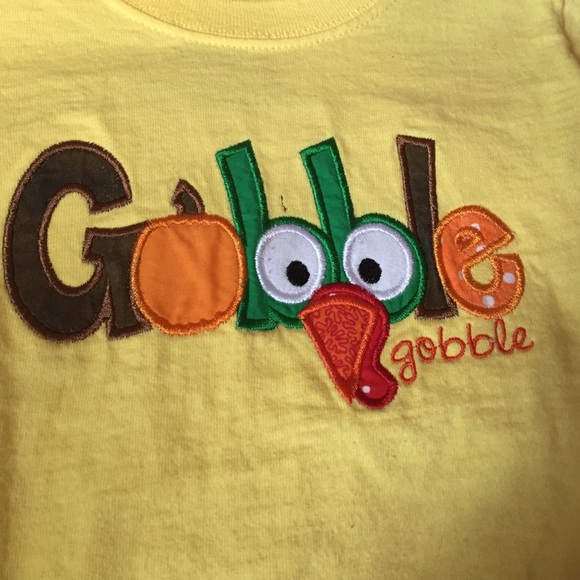 A yellow thanksgiving shirt that says gobble.