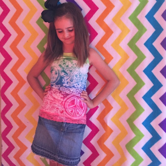 A multi color tank top and a blue jean skirt.