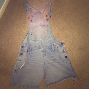 A light blue Denim Overalls that have shorts.
