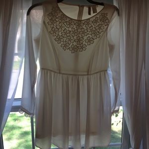 White long-sleeve dress with floral detail.