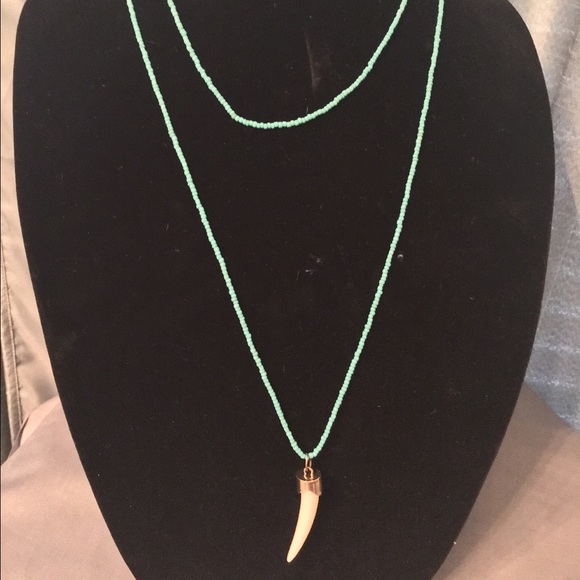Blue beaded necklace with ivory tusk charm