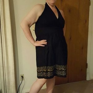 Black halter dress with embellished hem.