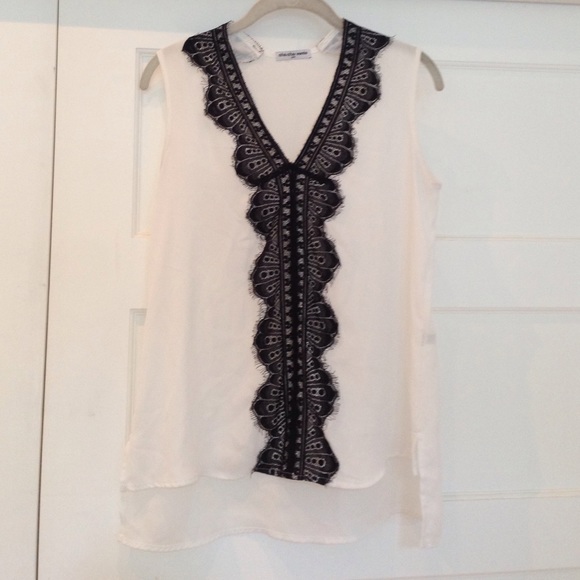 White sleeveless blouse with black lace trim