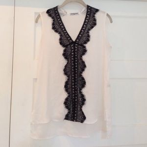 White sleeveless blouse with black lace trim