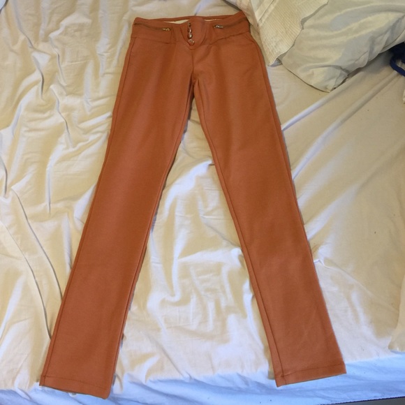 Orange jeggings with button and zipper design