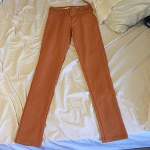 Orange jeggings with button and zipper design