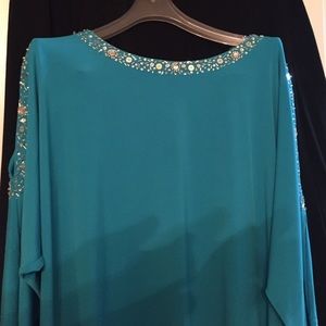 Sequined sea blue top with sequined open shoulder.