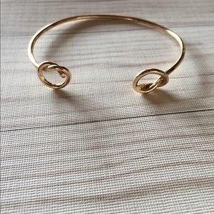 Double knot gold toned bangle bracelet