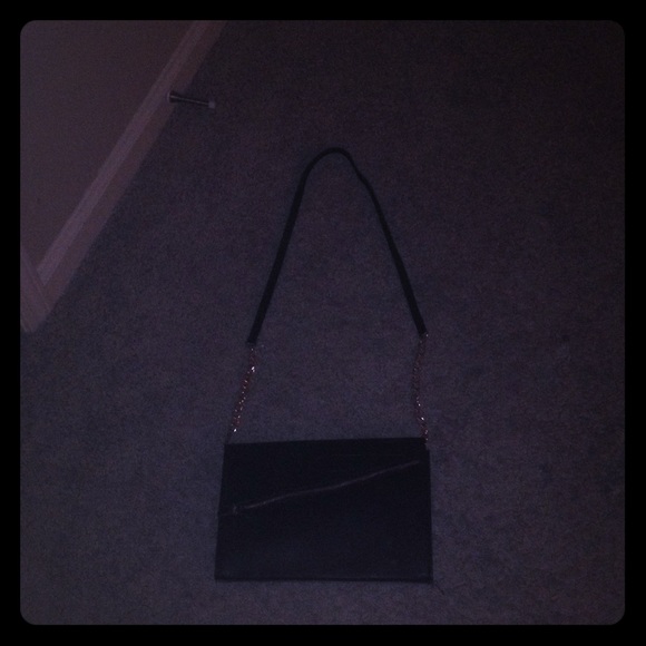 A black shoulder purse with a gold chain