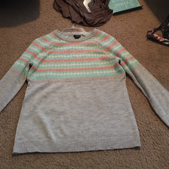 Grey, peach , and light blue sweater .