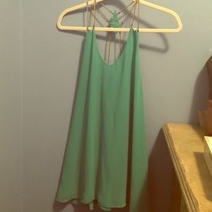 Chain-lined, backless emerald colored dress.