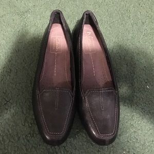 A pair of black flats made by Clarks.