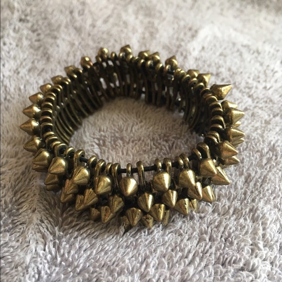 A brass colored, metal bracelet