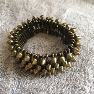 A brass colored, metal bracelet