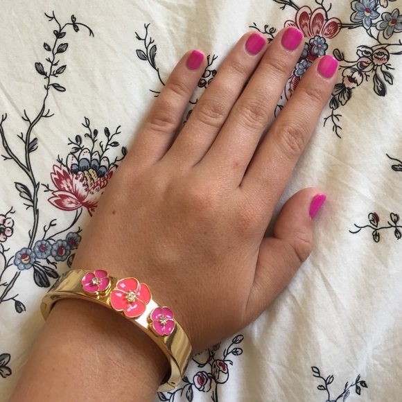 Kate Spade Gold Bangle with pink flowers.
