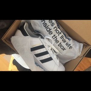 Black and white adidas superstars