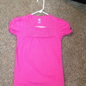 A pink shirt with a rose neck line