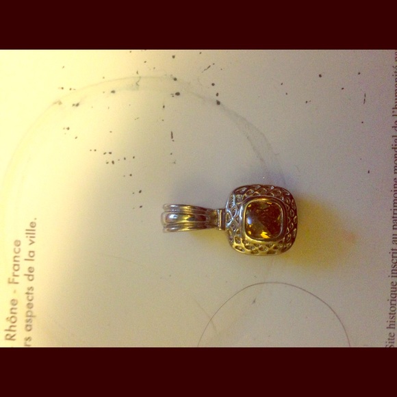 Silver charm incased with the yellow gem