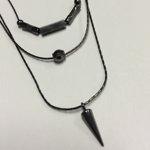A 3 level black tone necklace with 3 pendants.