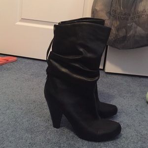 Black mid-calf boots with a buckle on the back