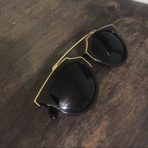 Gold and black sunglasses on hold