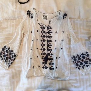 White blouse with tassels and patterned areas