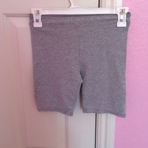 Grey mid-thigh shorts.