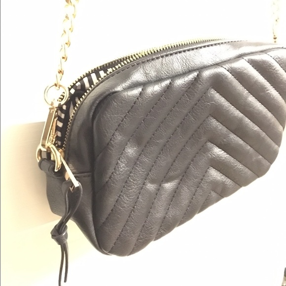 Small cross body purse with gold colored hardware.