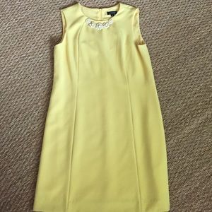 Sleeveless dress with metal daisies at the neck