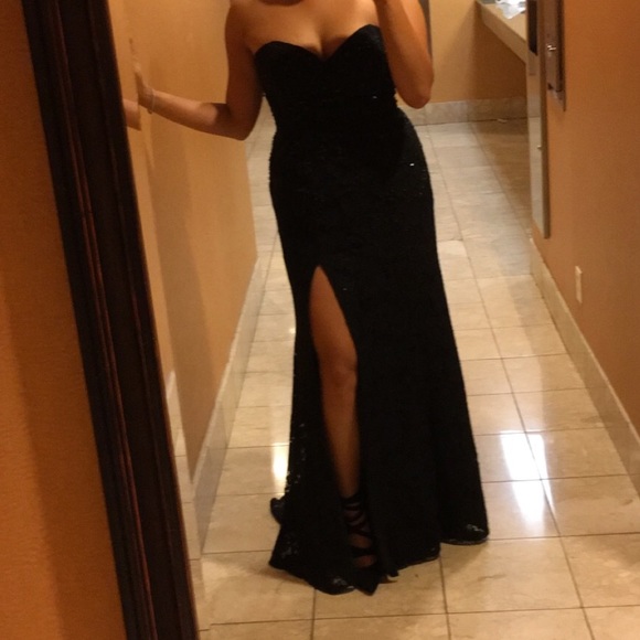 Floor length black sequin gown with slit.
