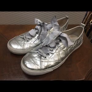Coach silver tennis shoes with ribbon ties.