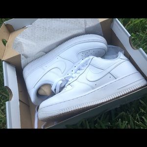All white low-top Nike Air Force Ones.