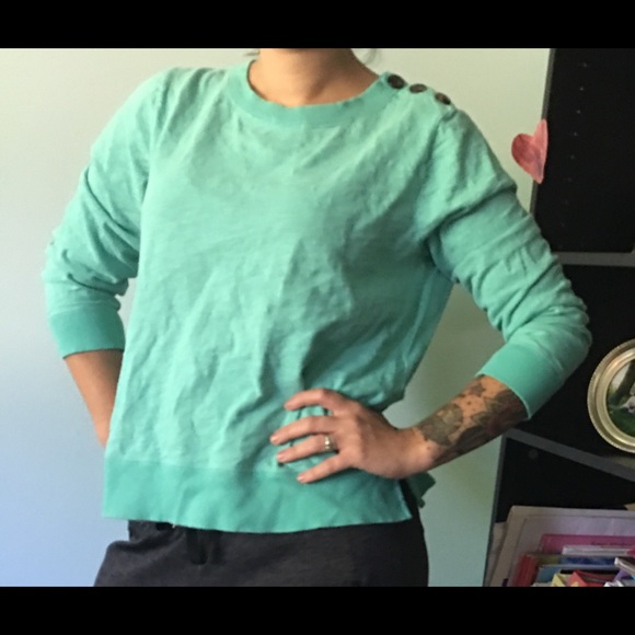 Teal sweatshirt with button detail.