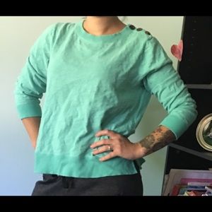 Teal sweatshirt with button detail.