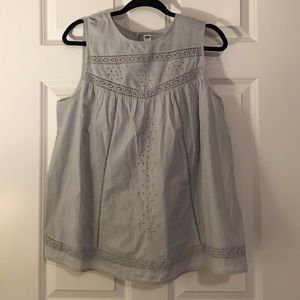 Grey sleeveless blouse.