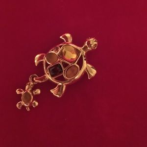 Turtle pin with dangling baby turtle.