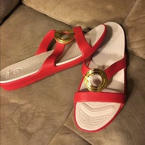 Brand new red crocs with gold circle size 10