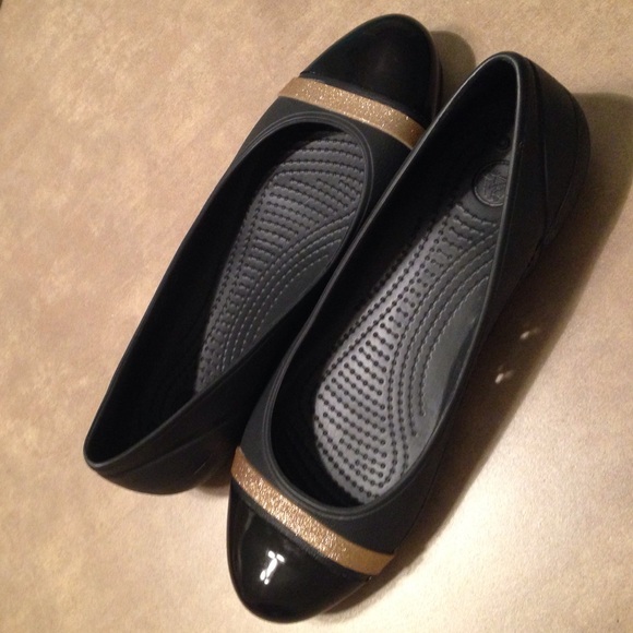Black and gold cap toe crocs.