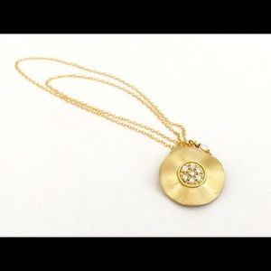 Gold necklace with gold disk and crystal stones.