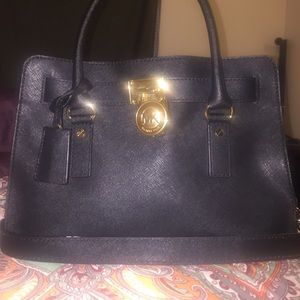 Michael Kors all black purse with gold chain.