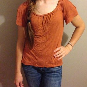 Burnt orange shirt with peek a boo shoulders.