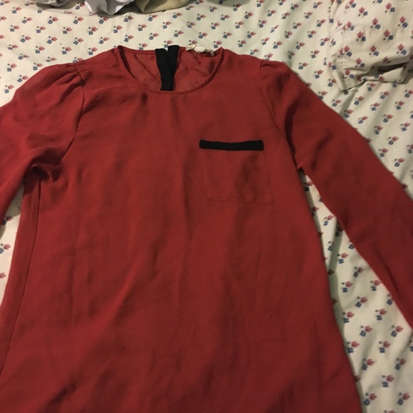 An orange sheer top with buttons done the back